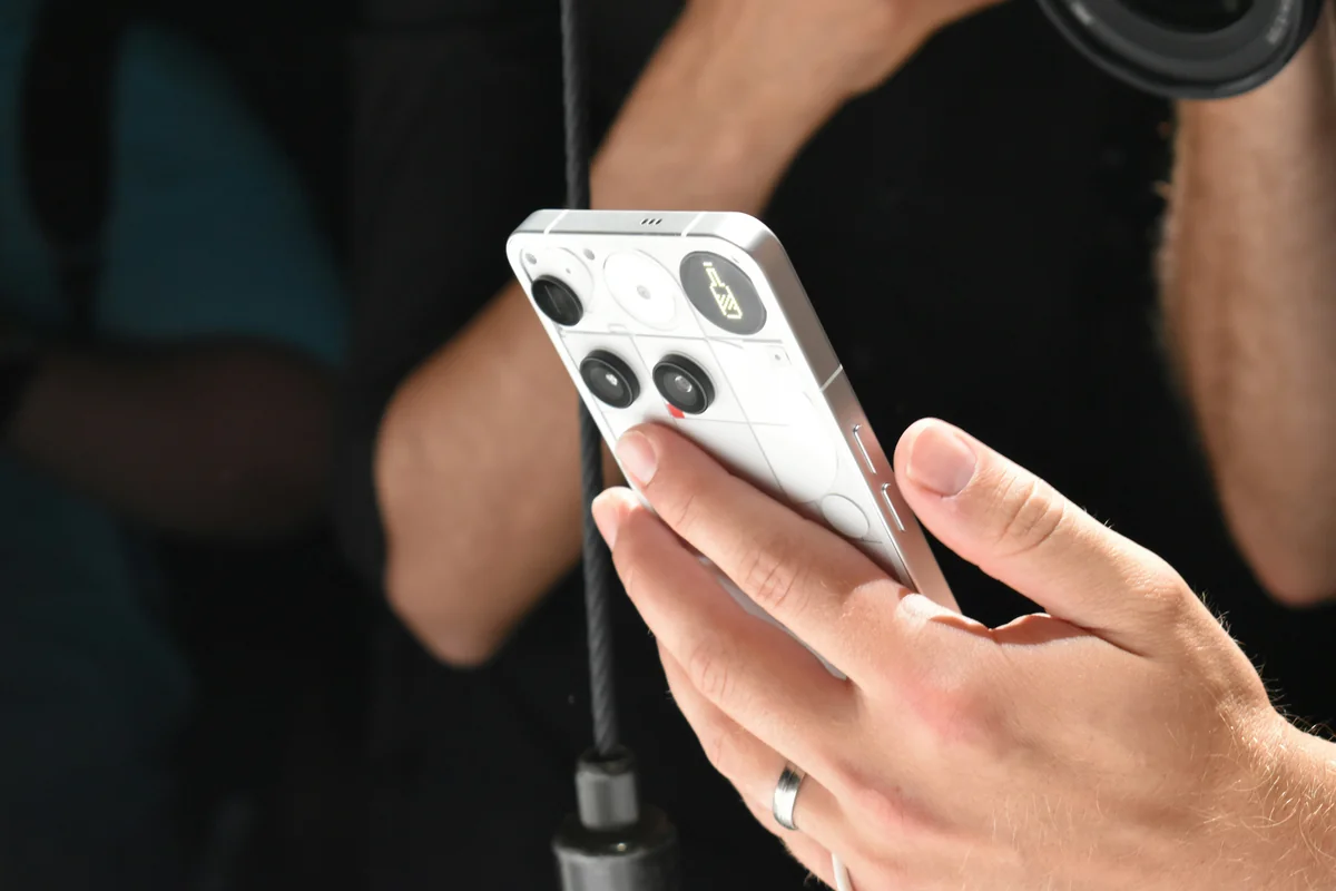 Person holding a white smartphone with a camera lens - smartphone technology - box tv android