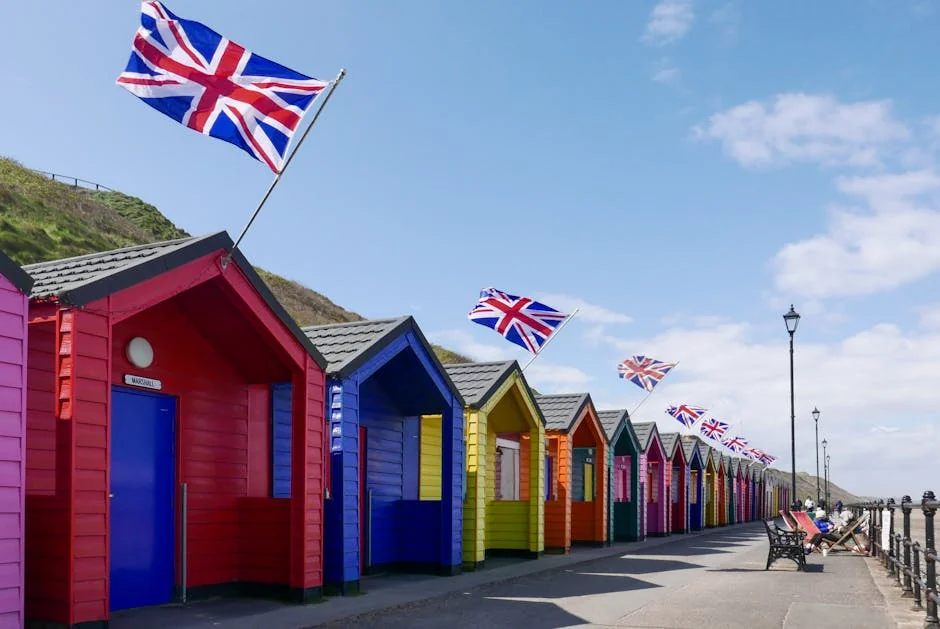 Colorful beach huts with Union Jack flags in Saltburn-by-the-Sea, England, under a clear blue sky. - iptv uk