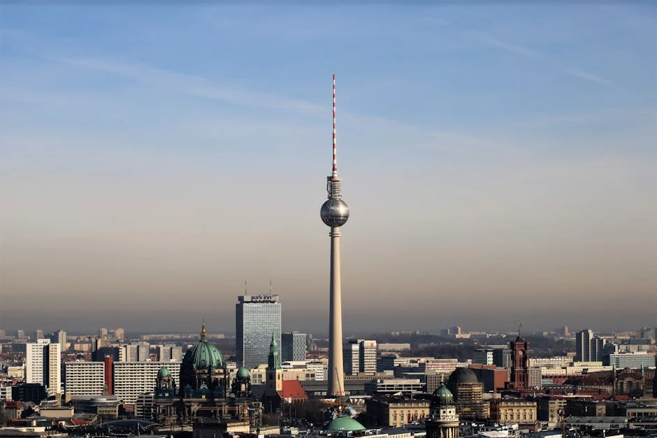 Admire Berlin's urban skyline featuring the iconic Fernsehturm tower against a clear blue sky. - iptv deutschland