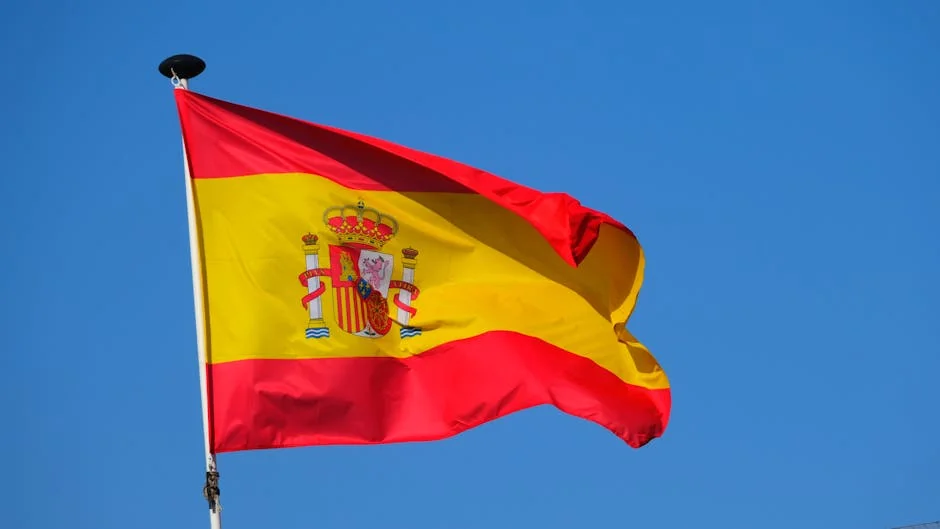 Bright Spanish flag waving against a clear blue sky, showcasing national pride. - iptv espaa