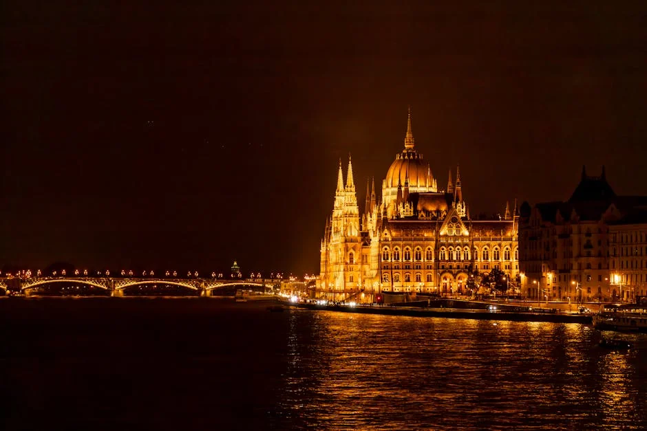 Stunning view of the illuminated Budapest Parliament and bridge reflecting on the Danube River at night. - iptv europe