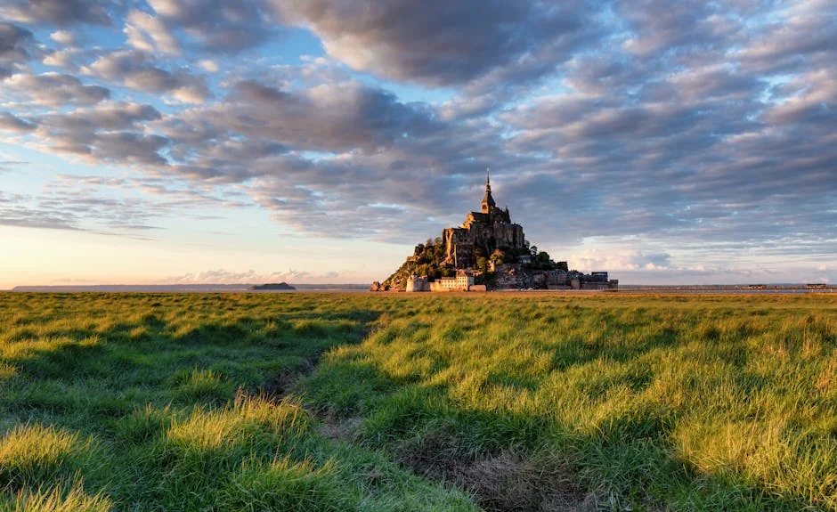 Capture of Mont Saint-Michel in Normandy during sunset over lush green fields. - iptv france