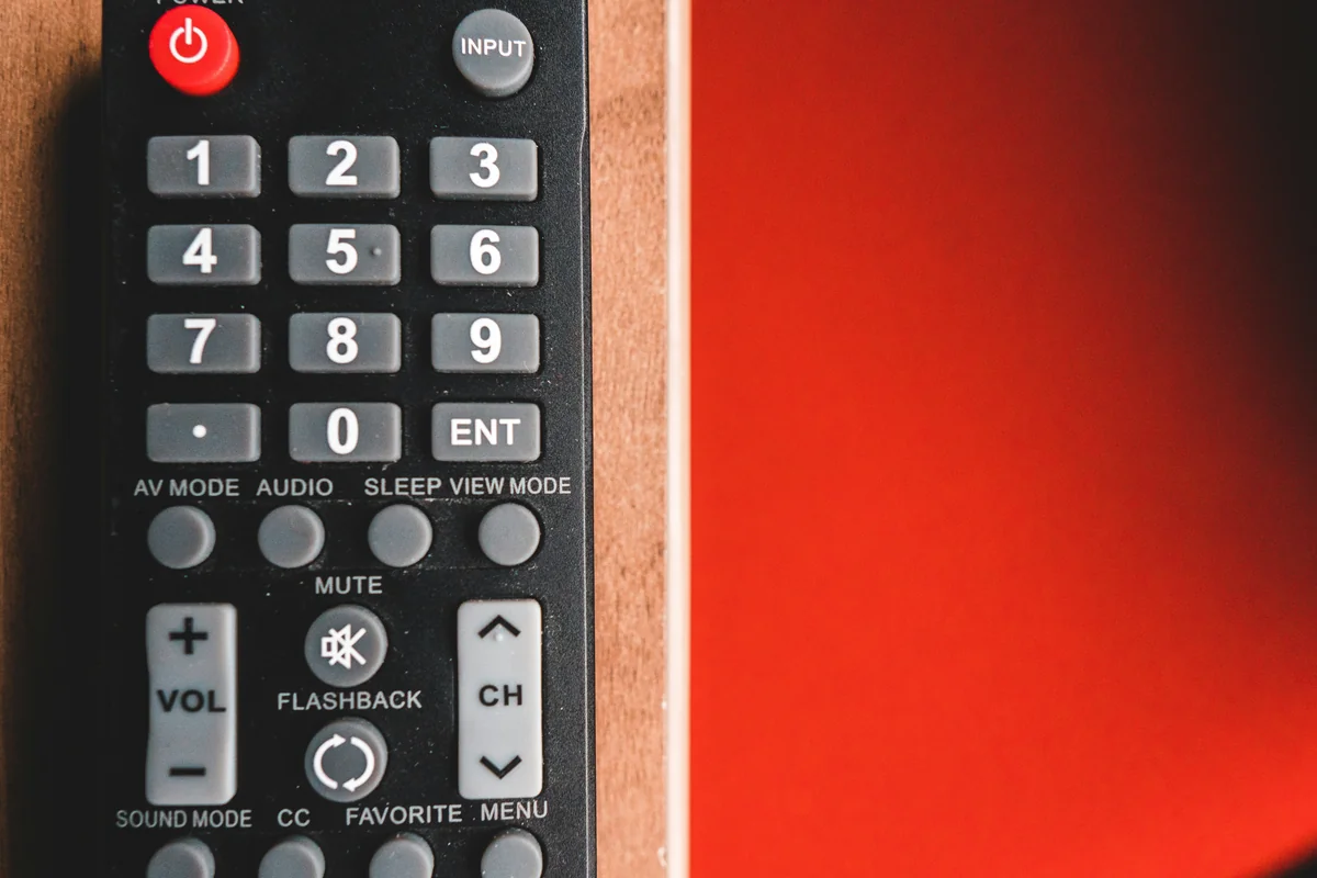 black remote control on red surface - iptv list