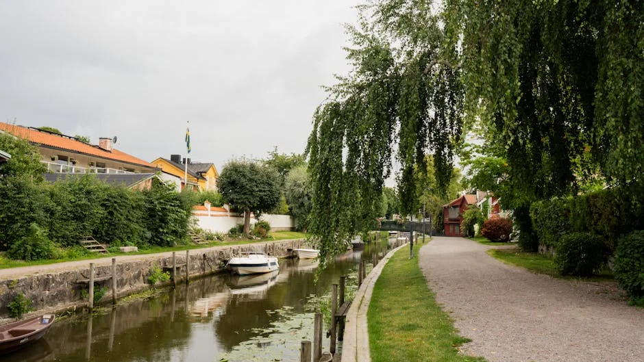 Picturesque canal and pathway in Trosa, showcasing Swedish architecture and summer greenery. - iptv livego swedish