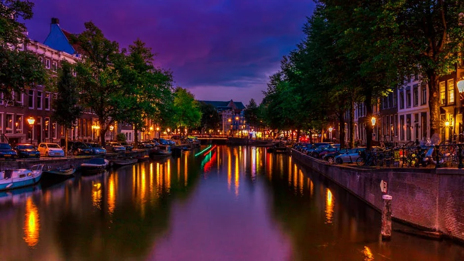 A vibrant night scene of Amsterdam's canal with colorful reflections and city lights. - iptv netherlands