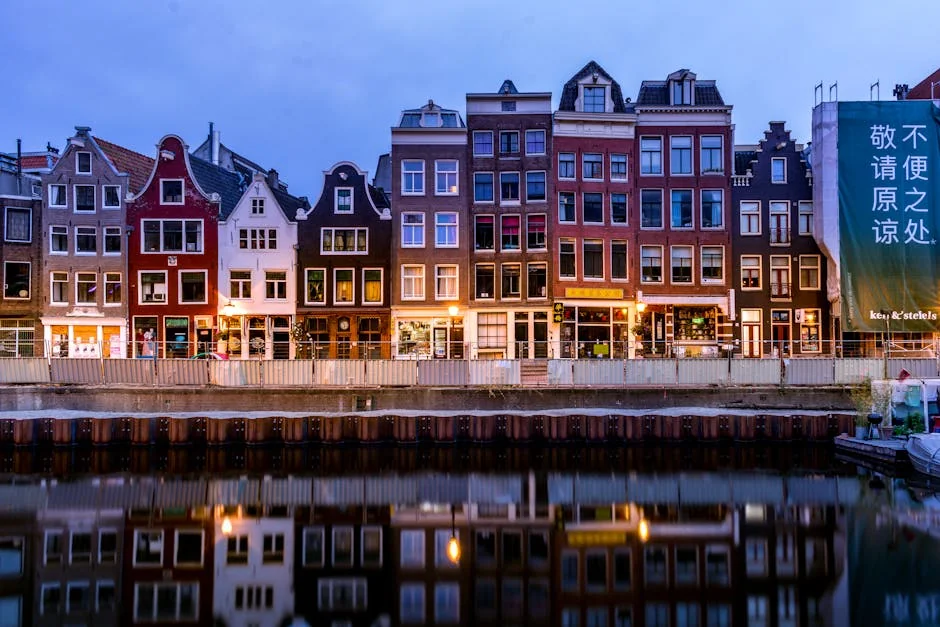 A picturesque view of colorful canal houses reflecting on the water in Amsterdam, Netherlands. - iptv netherlands