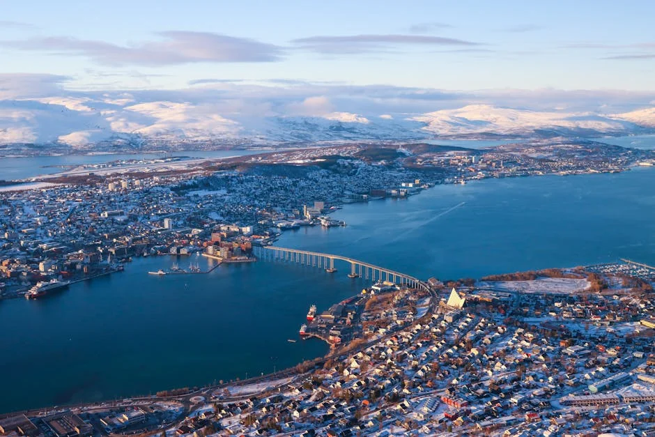 Panoramic aerial view of Tromsø, Norway, showcasing snow-capped mountains and the iconic Arctic Cathedral. - iptv nordic
