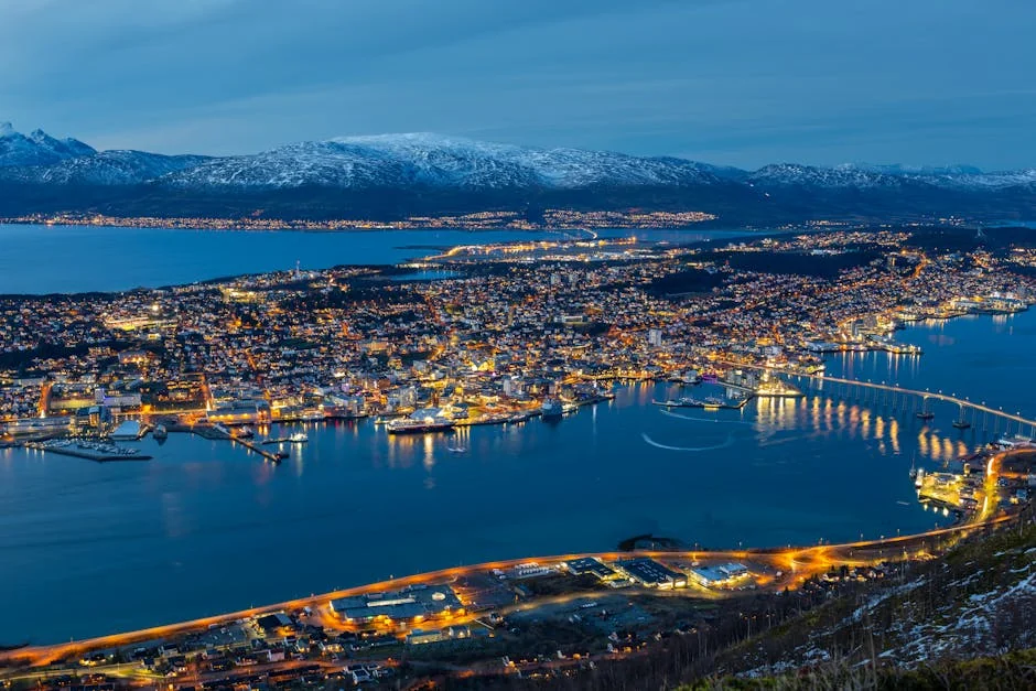 Stunning aerial view of Tromsø at night. Illuminated cityscape with harbor and mountains, captured in vibrant colors. - iptv nordic